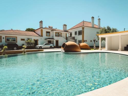 a large swimming pool in front of a house at Quinta das Pinheirinhas in Tomar