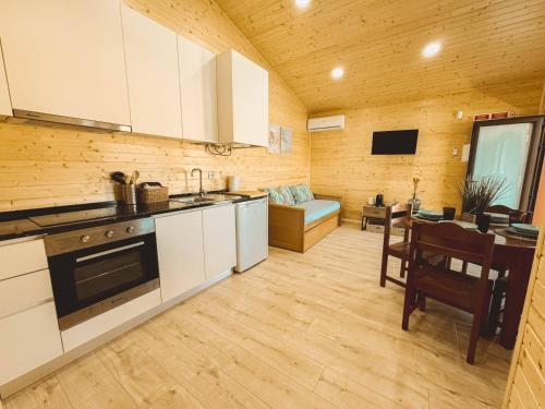 a kitchen with white cabinets and a dining room with a table at Quinta das Pinheirinhas in Tomar