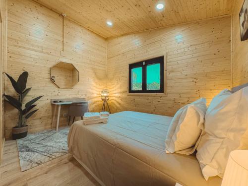 a bedroom with a bed in a wooden wall at Quinta das Pinheirinhas in Tomar