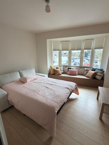 a bedroom with a large bed and two windows at Sien Suite in Brakel