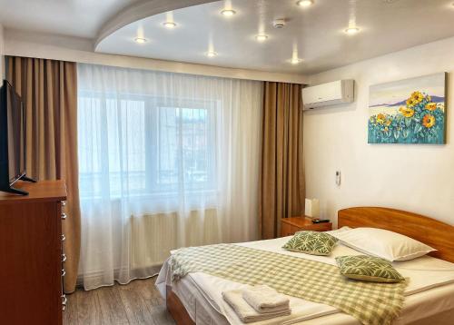 a hotel room with a bed and a window at BlueBee Apartment in Orăştie