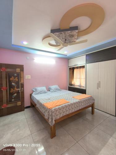 a bedroom with a bed and a ceiling fan at Dev Homestay kakinada in Kākināda