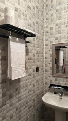 a bathroom with a sink and a mirror and towels at Andalous in Aït Ali