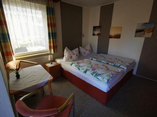 a hotel room with a bed and a table and a chair at Ferienwohnung Schulrath in Eichwerder