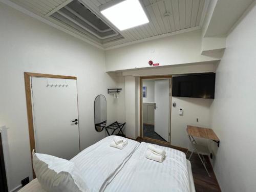 a bedroom with a large white bed and a mirror at Oxbackens Hotell & Café in Västerås