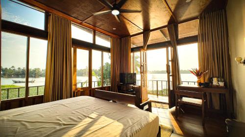 a bedroom with a bed and a view of the water at Kyna Backwater Resort Alleppey Alappuzha in Alleppey