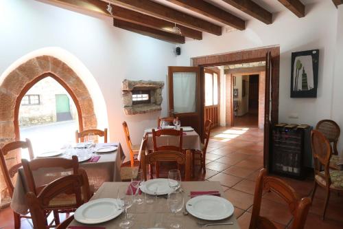 a dining room with tables and chairs and an archway at Hotel Rural CHOUSA VERDE in Vegacervera