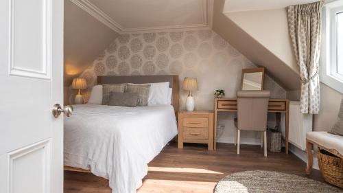 a bedroom with a bed and a desk with a chair at Shore View Cottage in Inverness