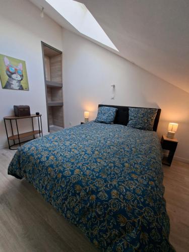 a bedroom with a large bed with a blue comforter at gîte 6 personnes le cocon des pommes in Saint-Lambert-et-Mont-de-Jeux