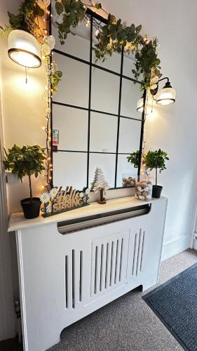 a white table with potted plants on top of it at Trinity House London Walthamstow in London
