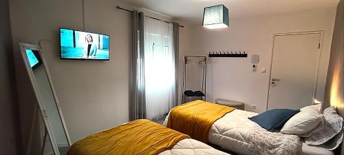 a room with two beds and a tv on the wall at Casa 2 Andrades in Belmonte