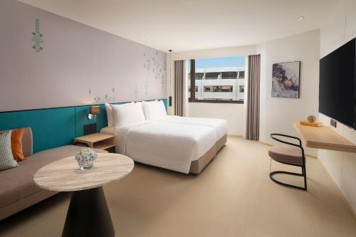 a hotel room with a bed and a table at Amari Don Muang Airport Bangkok in Bangkok