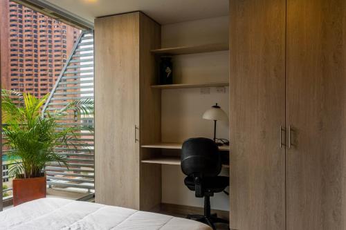 a bedroom with a desk and a chair next to a window at Confortable Apartamento Centro de Bogotá in Bogotá