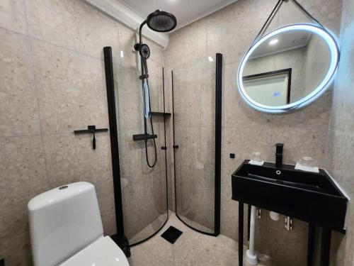 a bathroom with a shower and a sink and a mirror at Oxbackens Hotell & Café in Västerås