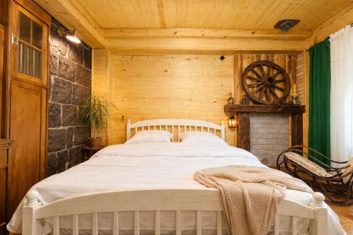 a bedroom with a white bed in a wooden room at Alashkert Guesthouse Premium and Cozy Studios in Gyumri in Gyumri