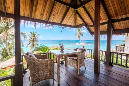 a dining room with a table and chairs on the beach at Beyond The Blue Horizon Boutique Bungalows in Haad Chao Phao