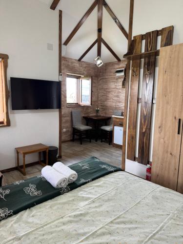 a bedroom with a large bed and a table at Apartmani Mladenovac in Mladenovac