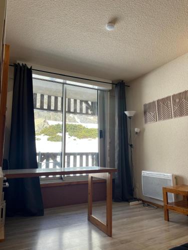 a room with a table and a large window at Ski Piau-Engaly balcon vue sur montagne pied pistes proche commerces in Aragnouet