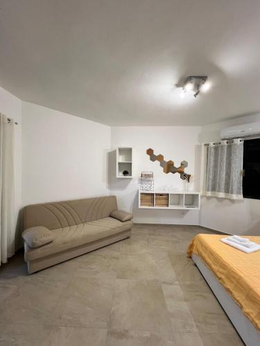 a living room with a couch and a bed at Casa Anna in Costa Rei