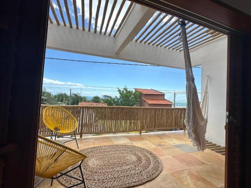 a patio with a table and chairs on a balcony at Casa Tartaruga Emboaca Trairí in Trairi