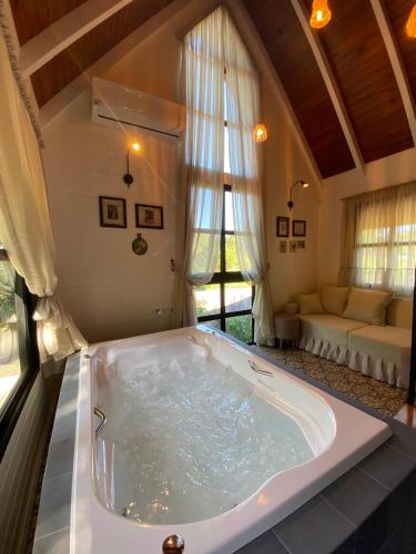 a large bath tub in a room with a couch at Cabana Vale das Bromélias in Videira