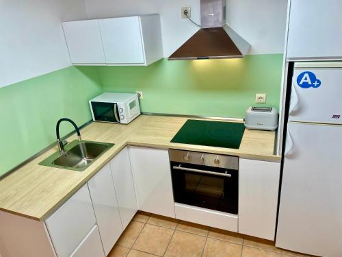 a small kitchen with a sink and a refrigerator at Puertoplaya 2 in Malpica
