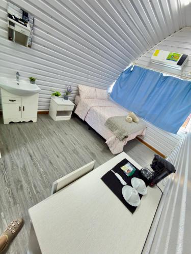 a small bedroom with a bed and a table at Paulos View Lodge in Colonia