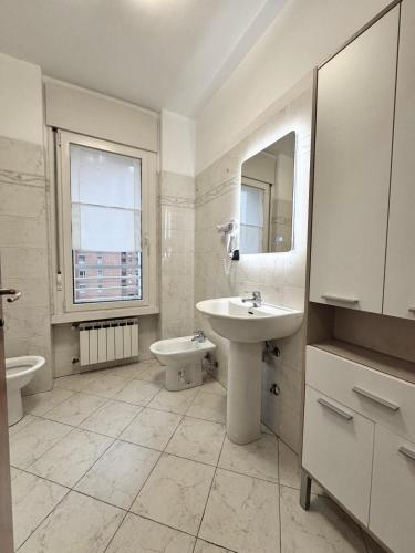 a white bathroom with a sink and a toilet at Torre Sole Fiumara in Genoa