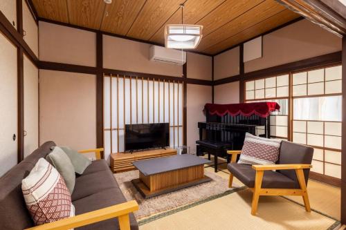 a living room with a couch and a piano at Irest village Ashikaga in Ashikaga