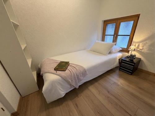 a bedroom with a bed with a book on it at Berna Signau Hab N3 Parking Naturaleza Terraza in Signau