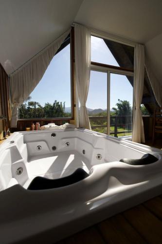 a large white bath tub in front of a window at cabana refúgio in Paulo Lopes