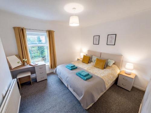 a bedroom with a bed and a desk and a window at Bright 3 bedroom townhouse near city centre in Norwich