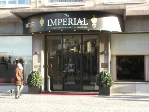 a man walking down the street in front of a store at Hotel Imperial in Ostend