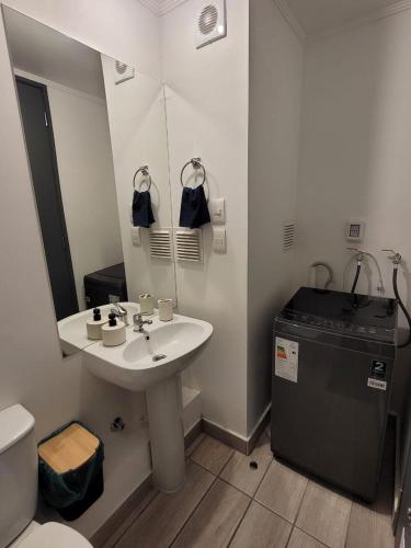a bathroom with a sink and a toilet and a mirror at Depto Comodo y full equipado in Antofagasta