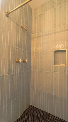 a bathroom with a shower with blue tiles at Thurston House Inn in Ocracoke