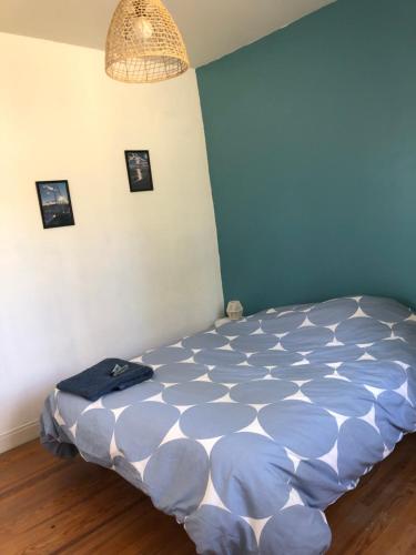 a bed in a room with a blue wall at Chez Cathy in Saint-Donat-sur-lʼHerbasse