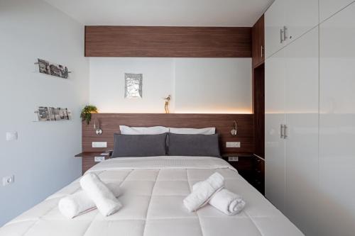 a bedroom with a large white bed with towels on it at Downtown Skyloft in Kalamata