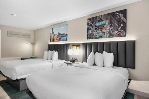 two beds in a hotel room with white sheets at La Quinta by Wyndham Nashville Airport/Opryland in Nashville