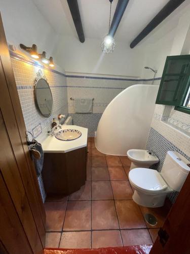 a bathroom with a tub and a toilet and a sink at Casa Isabel in El Gastor