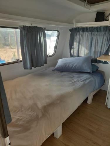 a large bed in a room in a trailer at Karoo Stone camper in Ladismith