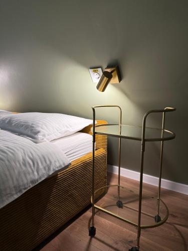 a bed with a glass table with a lamp next to it at Alpin Chalet & SPA in Mănăstirea Humorului
