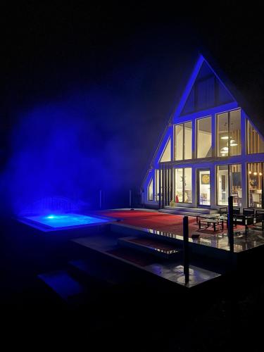a building with blue lights on it at night at Alpin Chalet & SPA in Mănăstirea Humorului