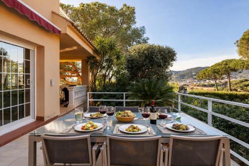 a table with plates of food on a balcony at Cabril's Hills - Stunning Villa with Pool & Sea Views in Cabrils