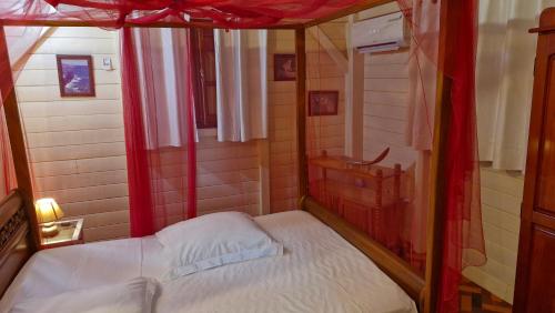 una piccola stanza con un letto a baldacchino di Ô Logis Zen' a Le Moule