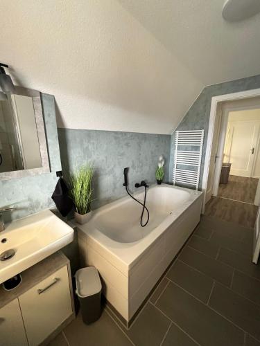 a bathroom with a large tub and a sink at Wunderschönes Haus am Waldrand für max 8 Personen in Harztor