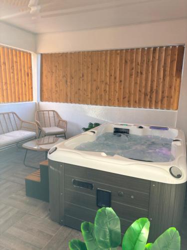 a jacuzzi tub in a room with two chairs at Hot Room Sainte Victoire in Trets