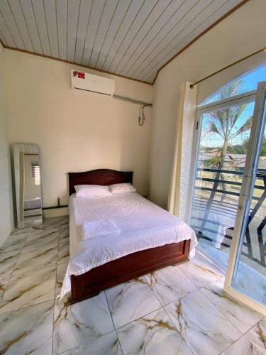 a bedroom with a bed and a large window at Alojamiento in Nueva Loja