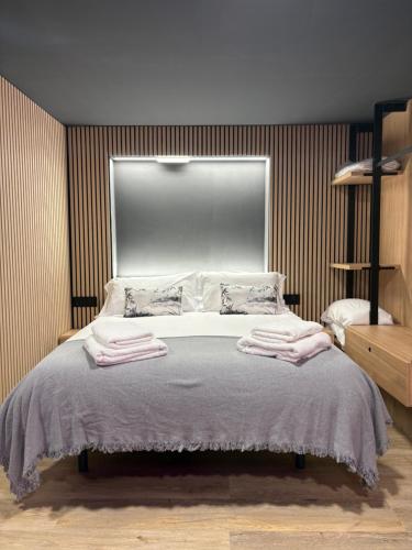 a bedroom with a bed with towels on it at Nómada Orzán bajo in A Coruña
