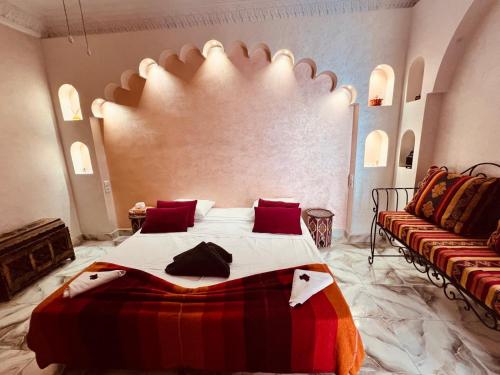 a bedroom with a large bed and a couch at Riad Les Chtis D'Agadir in Agadir