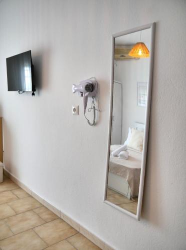 a mirror on a wall in a room with a bed at Seaside Stay Makrygialos in Makrygialos